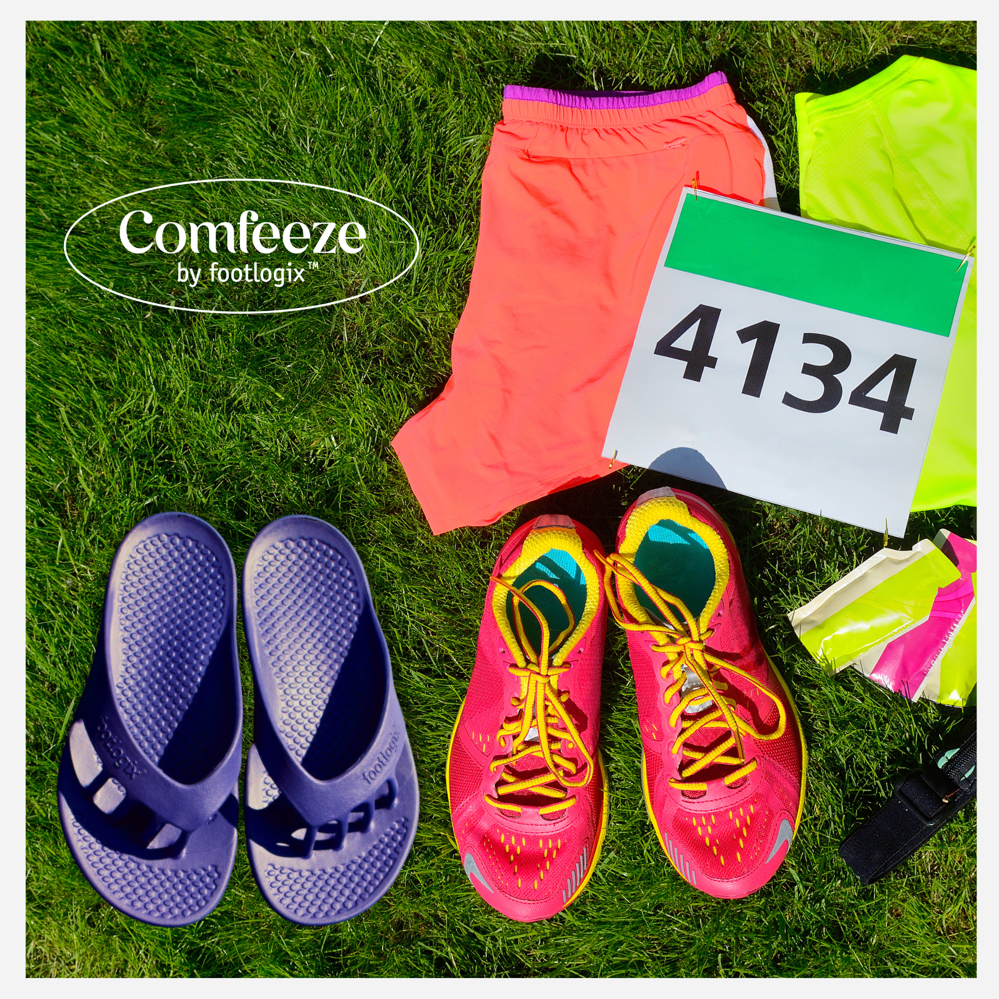 Comfeeze by Footlogix™ sandals placed beside running shoes, race bib, and athletic gear on grass, highlighting post-run comfort.