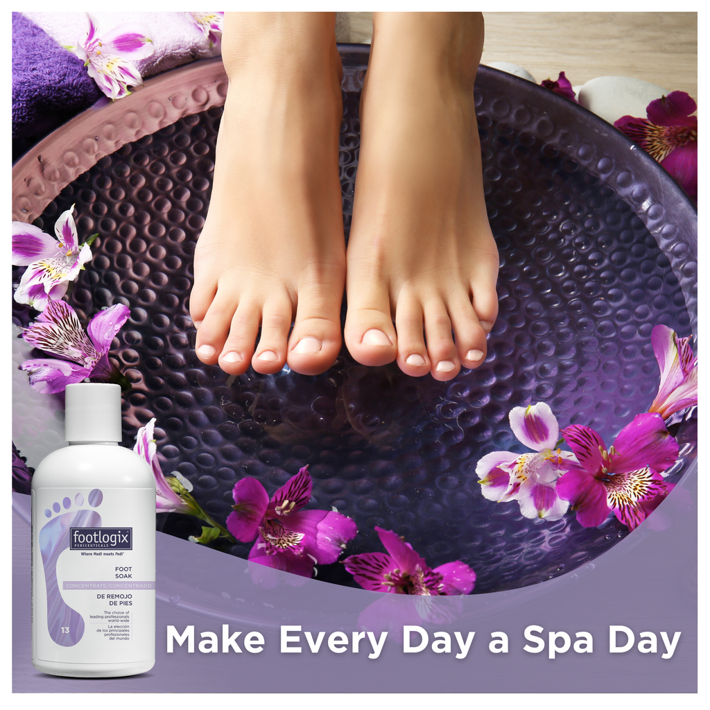 A pair of clean, well-groomed feet resting in a purple spa bowl surrounded by purple and white flowers, with a bottle of Footlogix Foot Soak Concentrate in the foreground and the tagline "Make Every Day a Spa Day" at the bottom.