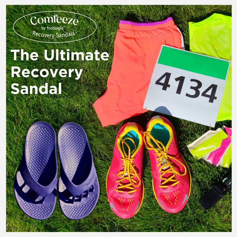 A pair of Comfeeze by Footlogix recovery sandals for women sitting beside a pair of running shoes and other running gear, along with a number bib from a running race. The headline states the ultimate recovery sandal. The image demonstrates how Comfeeeze by Footlogix sandals act as an ideal post-run recovery sandal.